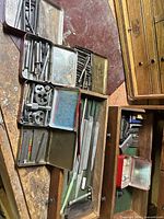 Overview of tins with taps, dies, drill bits and files on workbench