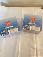 Two sealed trading card boxes side by side