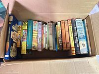 Books lined in box, left section showing rocket spine, Hardy Boys, New Books, Don Camillo etc.