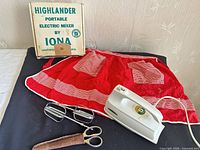 Mixer, apron, beaters, scissors with sheath displayed together