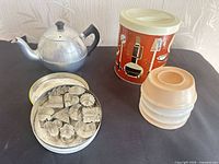 Overall lot showing teapot, canister, tin with cutters, stacked egg cups