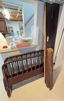 Headboard, footboard, side rails and supports leaning against wall