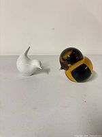 Porcelain and glass bird figurines side by side
