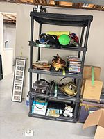 Full view of assembled five-shelf black plastic storage rack with various items on shelves (contents not included)