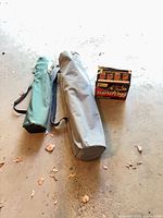 Overall lot showing two bagged camp chairs and StarterLogg box on garage floor