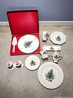Group shot of dinnerware set including hostess plate in red box, candlesticks, plates, creamer, sugar