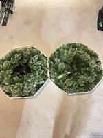 Two green pre-lit wreaths in storage trays