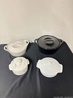 Group shot of four covered dishes showing size comparison and general condition