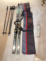 Full lot showing skis, two pole pairs, bag and boot carrier