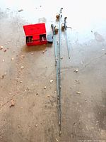 Three fishing rods with reels, tackle box and grey case on floor