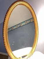 Full view of oval gold-tone mirror