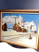 Full view of framed painting showing snowy rail station and tracks
