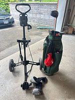 Overall view of Bag Boy push cart, green bag, clubs, shoes