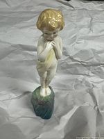 Front view of Royal Doulton porcelain boy figurine on rocky base