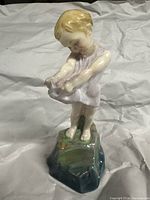 Front view of porcelain child figurine on rocky base