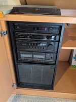 Front view of rack showing stacked stereo components inside cabinet