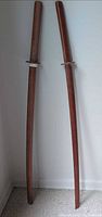 Both wooden bokken full length against wall