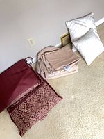 Sheet set packed with cushion and pillows on carpet