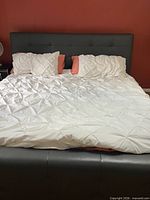 Front view of made king bed showing upholstered headboard and footboard