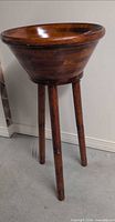 full view of wooden salad bowl on tall three-leg stand