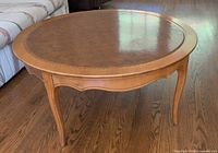 oblique view of entire round coffee table showing legs and apron