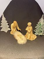 Group shot of ceramic nativity trio and two glass Christmas trees