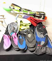 All items grouped: four pairs water shoes, snorkel gear, Super Soaker, towel, air mattress