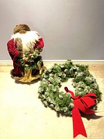 Santa figure beside artificial wreath showing overall lot
