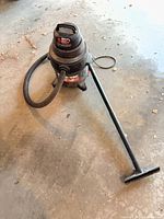 Full view of Shop-Vac with hose, extension wand and floor nozzle on concrete floor