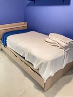 Full view of twin bed frame with mattress and bedding