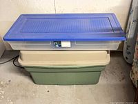 Clear long tote with blue lid stacked on green tote