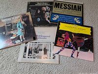 Five LP records laid out on carpet