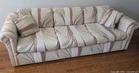 Full view of vintage three-seat sofa with throw pillow
