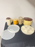 Group shot of all pitchers, trays, storage container and enamel pot