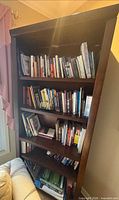 Front view of dark wood five-shelf bookcase filled with books (books not included)
