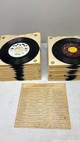 Two stacks of sleeved 45 RPM records with two records visible on top