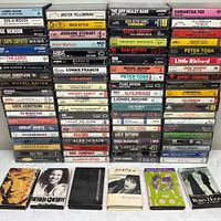Overall view of three tall stacks of cassette tapes plus five additional tapes laid flat in front