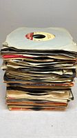 Tall stack of 7-inch vinyl singles in paper sleeves
