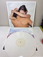 Front cover with embracing couple and white vinyl record displayed