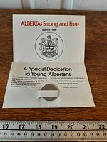 Medallion seated in open dedication card showing printed text and arms