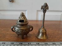Incense burner and bell side by side with scale