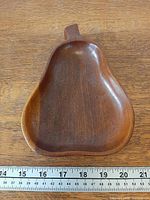 Top view of pear-shaped wooden dish with measuring tape