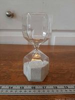 Full view of hourglass showing overall shape and size against ruler