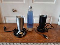Front view of globe between silver and black bases, cords visible