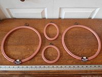 Four Flexi-Hoop plastic embroidery hoops laid out with ruler for scale