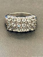 Front view of sterling silver ring displaying rectangular cluster of clear stones
