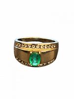 Front view of ring showing green stone and accent stones