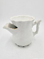 Front view of white porcelain shaving scuttle mug showing spout and handle