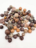 Top view of assorted gemstone beads spread out showing variety of colours, shapes and drilling