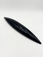 Full view of black elongated sculpture, top angle